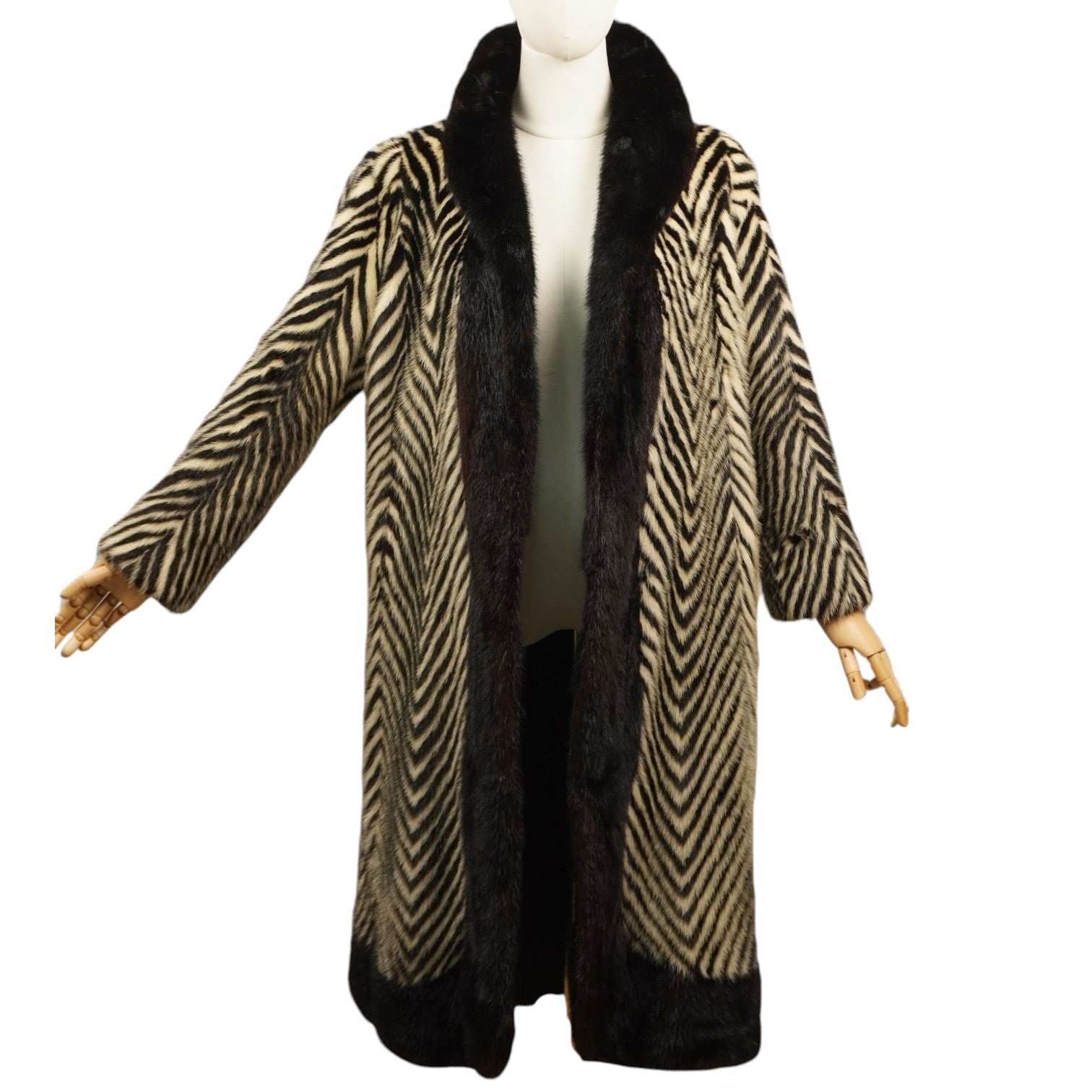 Vista frontale completa su manichino di un cappotto in pelliccia di visone Cesare Mangili con motivo chevron bianco e nero.