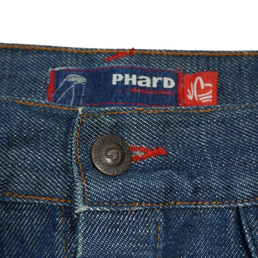 Dettaglio del bottone in metallo con cuore e etichetta interna in tessuto Phard denim only