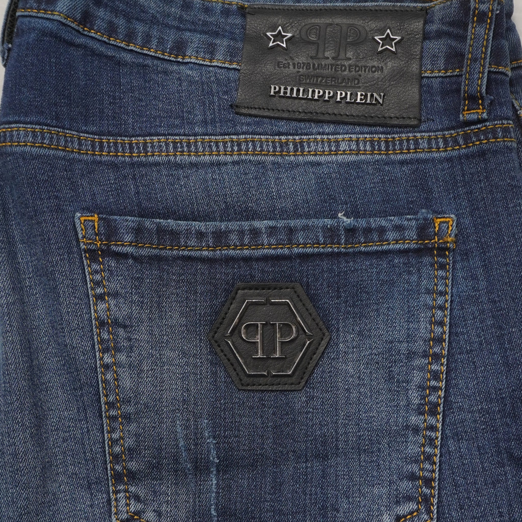 Dettaglio ravvicinato della tasca posteriore dei jeans uomo con placchetta esagonale PP e patch in pelle