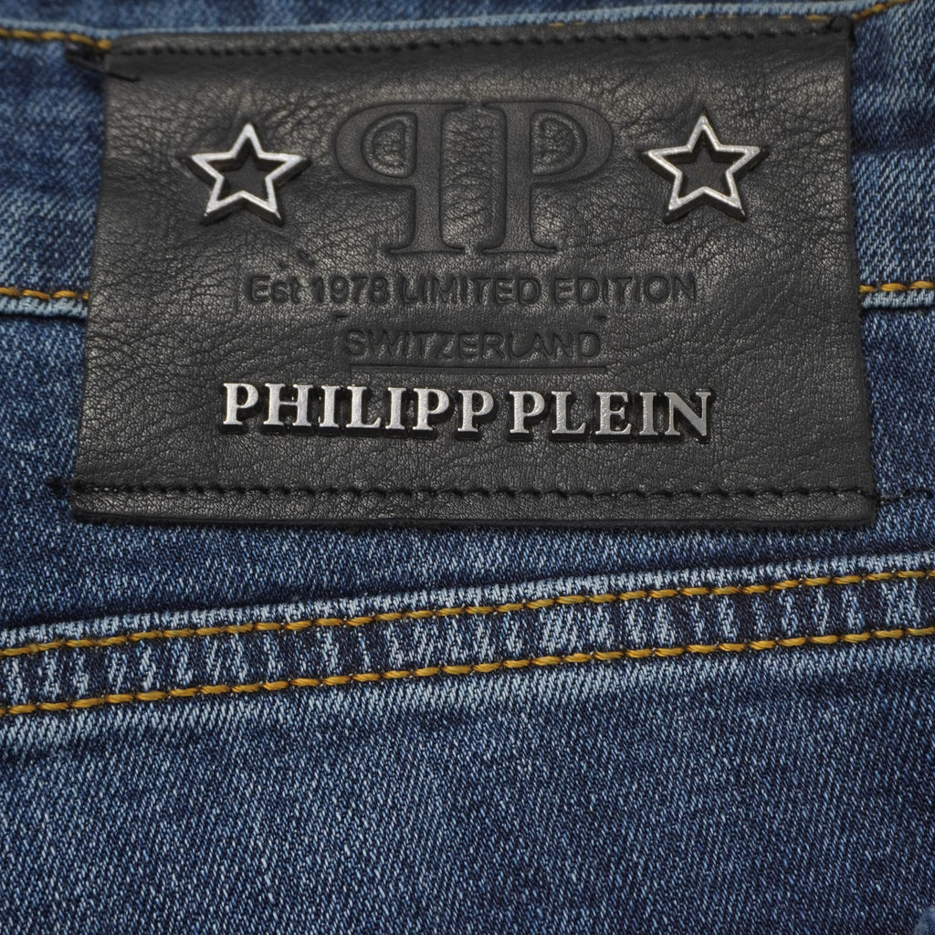 Primo piano macro della patch posteriore in pelle nera dei jeans Philipp Plein con stelle metalliche e scritte