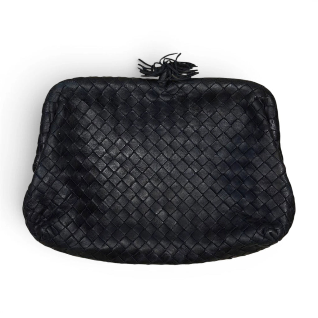 Inquadratura dall'alto in piano di una borsa pochette vintage Bottega Veneta in pelle intrecciata nera.