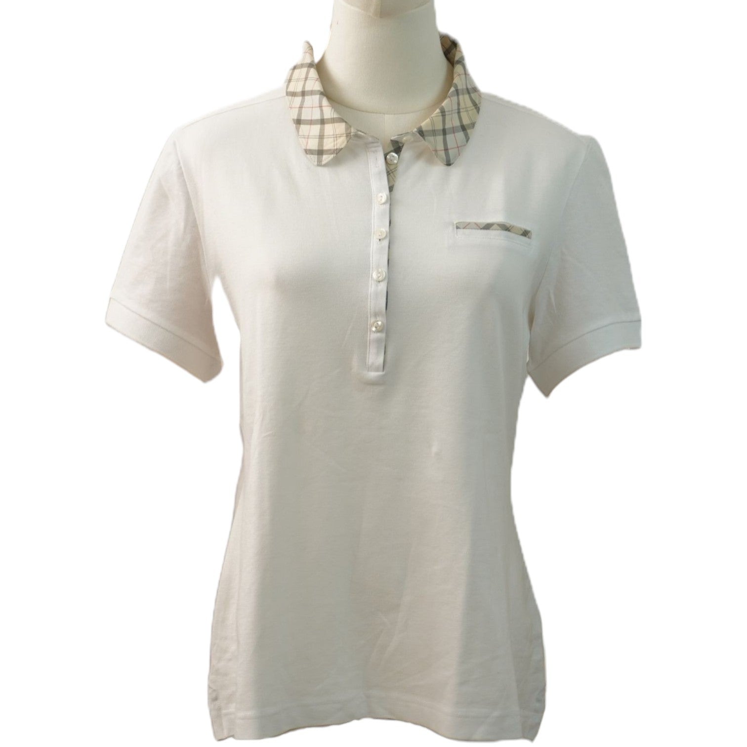Polo bianca da donna a maniche corte firmata Barbour su manichino, vista frontale con colletto tartan.