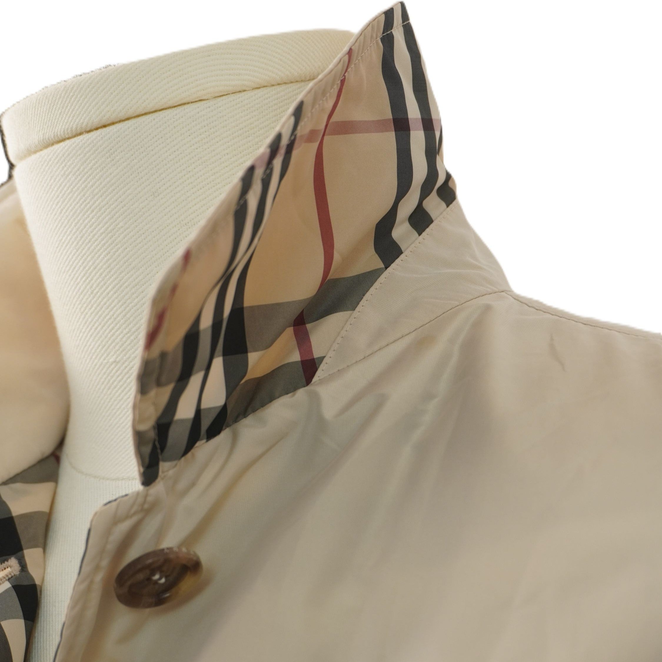 Dettaglio ravvicinato della cucitura e della fodera Nova Check sul colletto della giacca beige Burberry London.