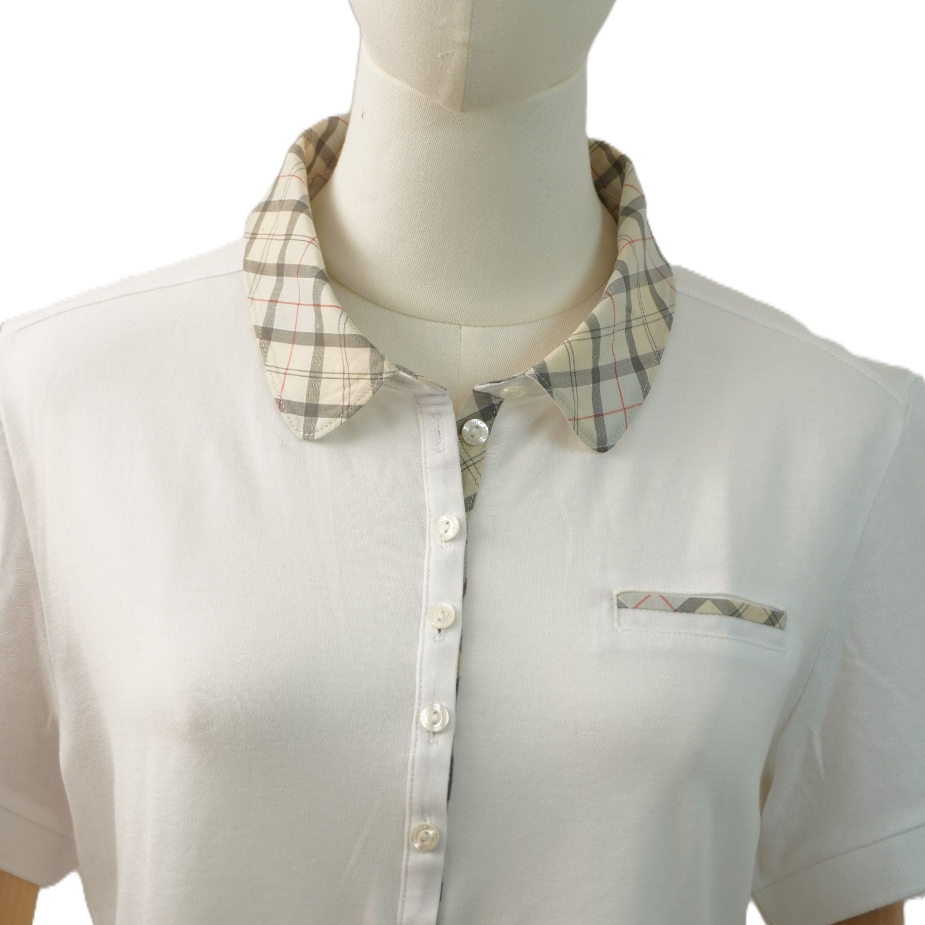Dettaglio frontale a mezzo busto del colletto in tartan beige e dell'abbottonatura allungata.