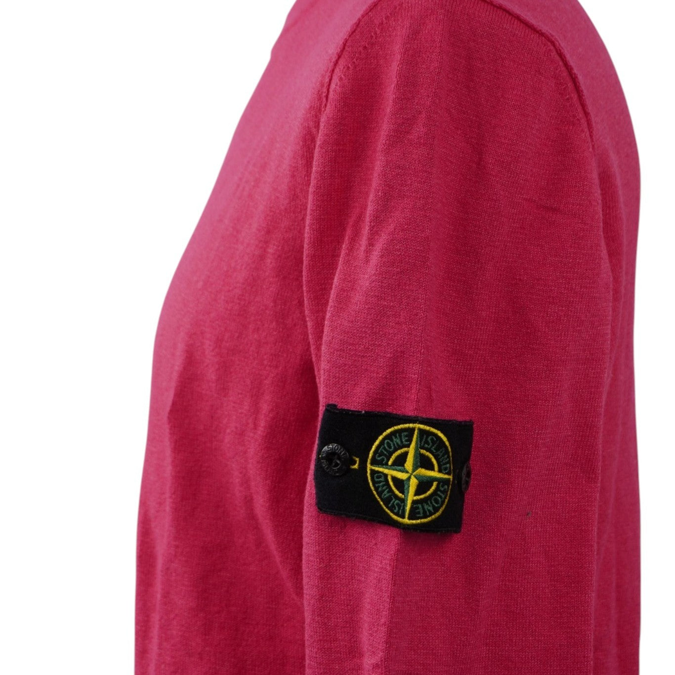  Vista laterale di profilo della manica sinistra del maglione rosa ciclamino indossato dal manichino, focalizzata sul posizionamento del badge