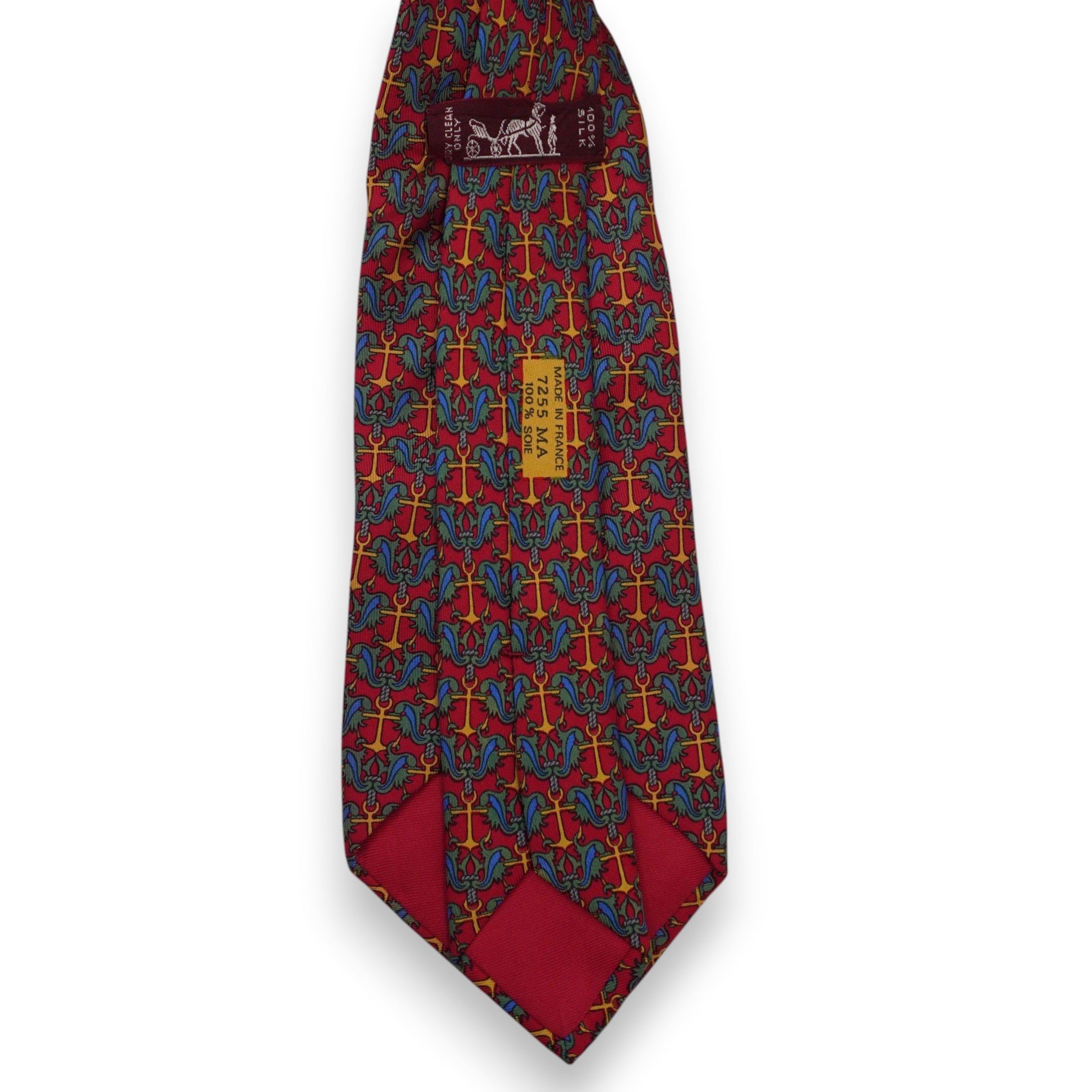 Vista posteriore del retro della cravatta rossa Hermès con il passante istituzionale marrone e le stampe di autenticità sulla seta.