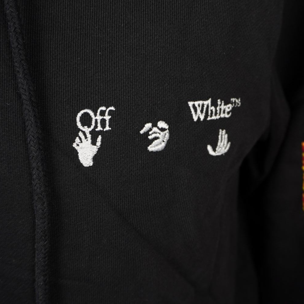Primo piano del logo Off-White Hands Off ricamato in bianco sul lato sinistro del petto