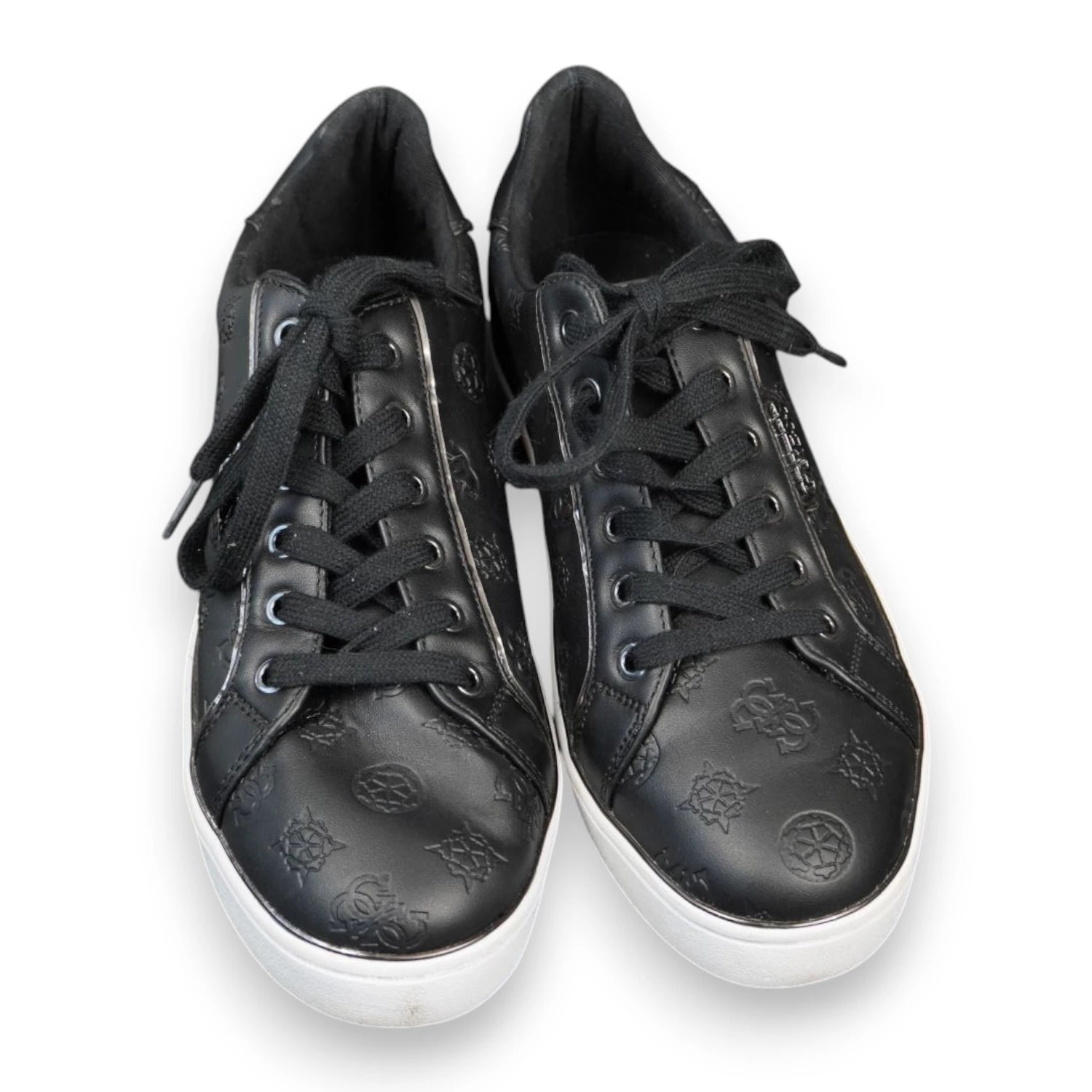 Inquadratura dall'alto a tre quarti di un paio di sneakers nere Guess con stringhe nere