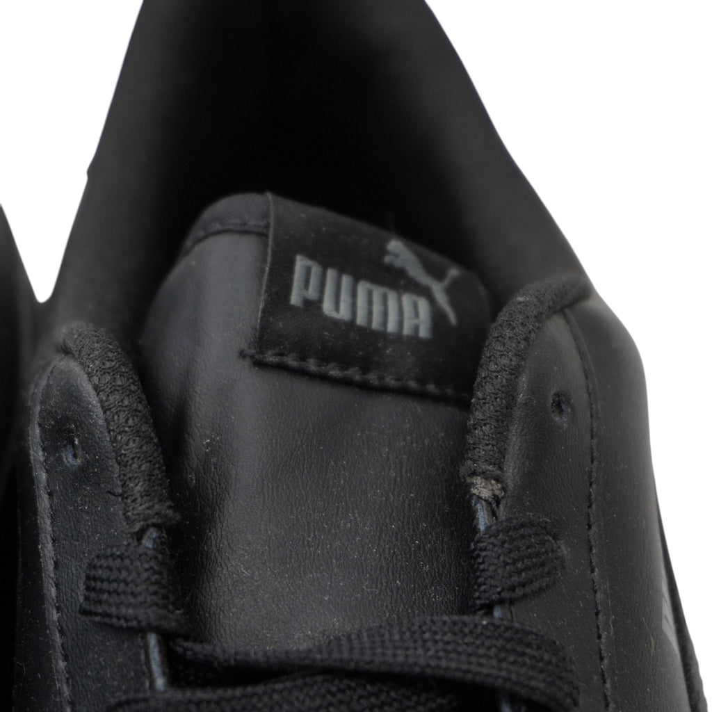Primo piano dell'etichetta nera con logo grigio cucita sulla linguetta delle PUMA Smash.