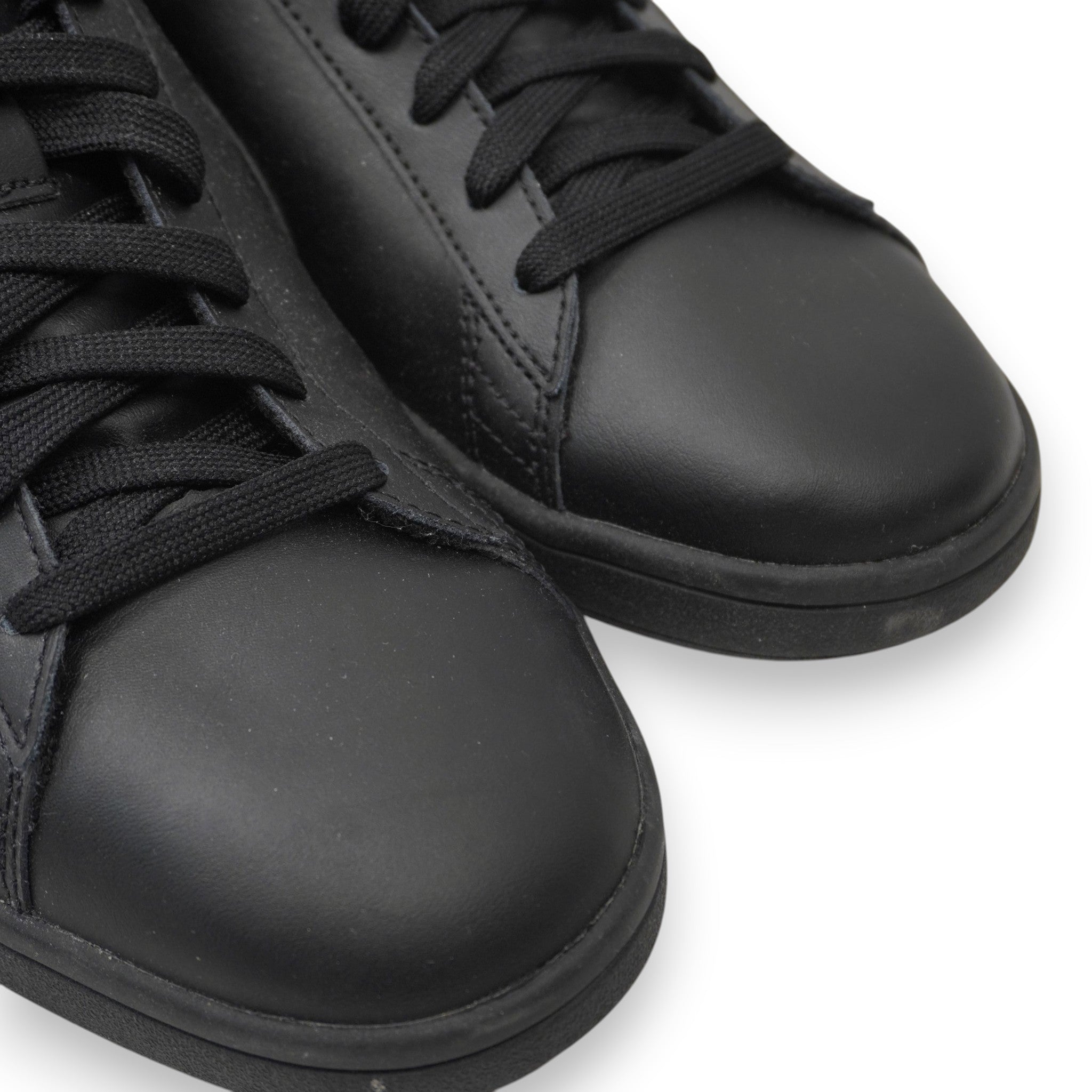 Primo piano ravvicinato delle punte in pelle nera delle sneaker PUMA Smash da uomo.