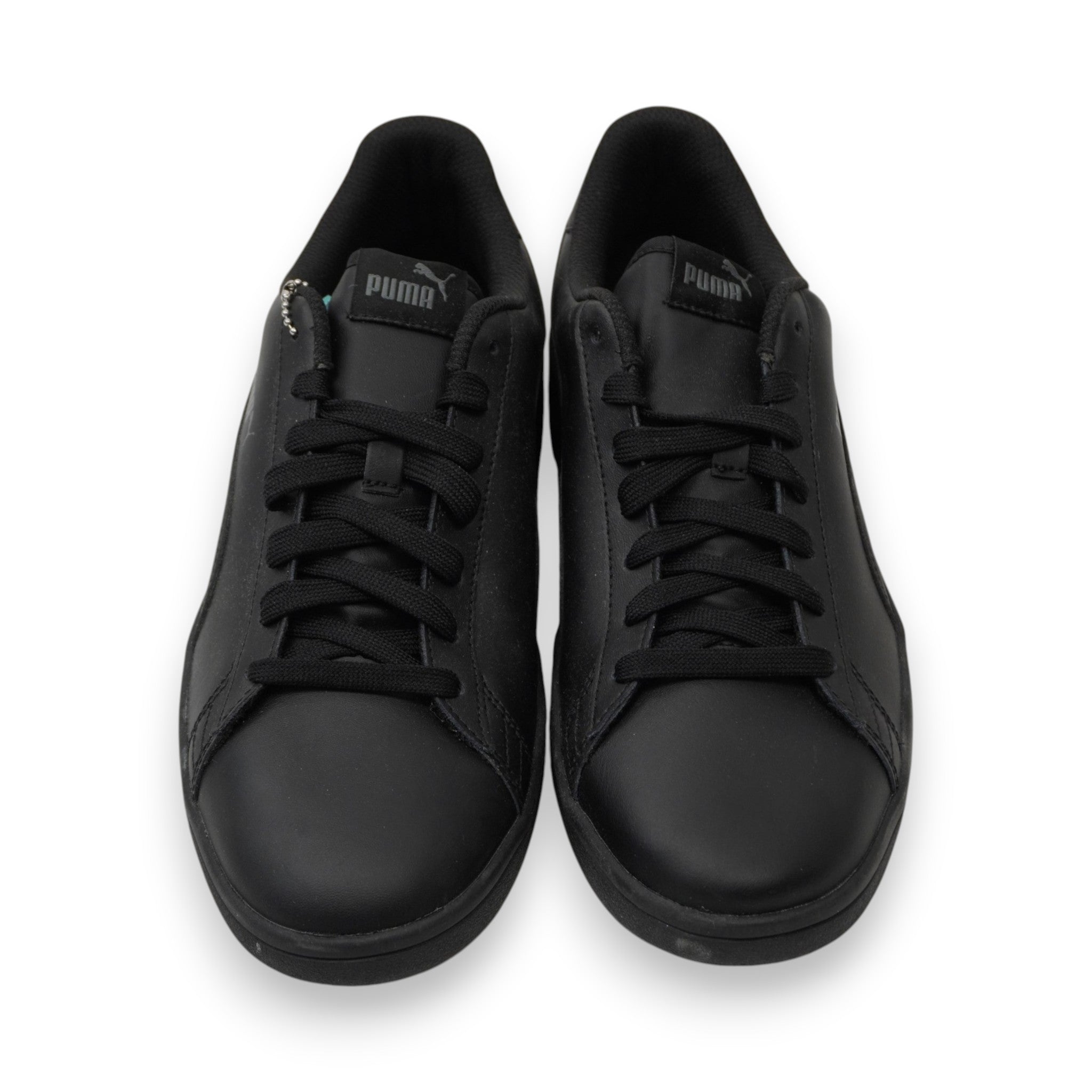 Inquadratura frontale simmetrica del paio di sneaker da uomo PUMA Smash in pelle nera.