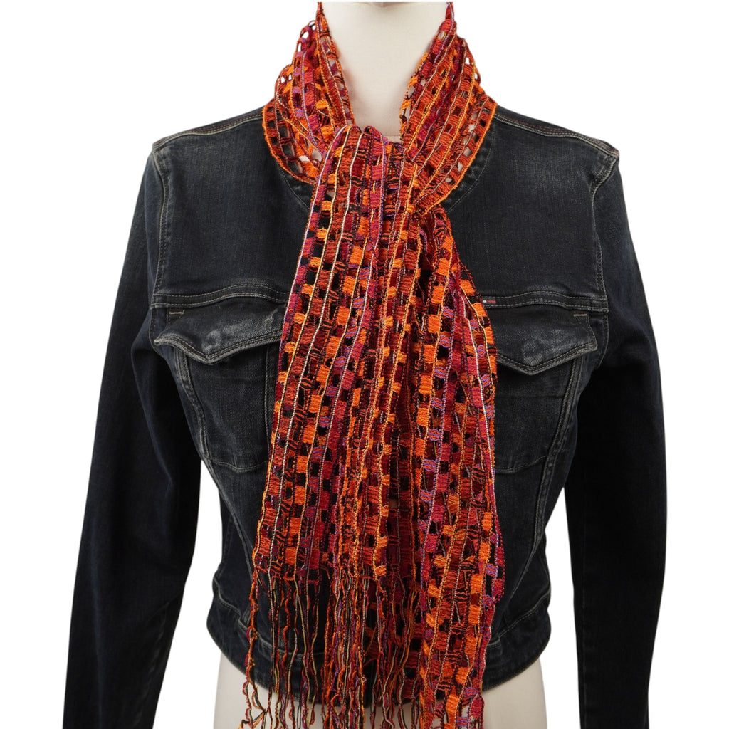 Sciarpa vintage Missoni a rete multicolor arancio e rossa con frange, indossata su un manichino con giacca in pelle nera.