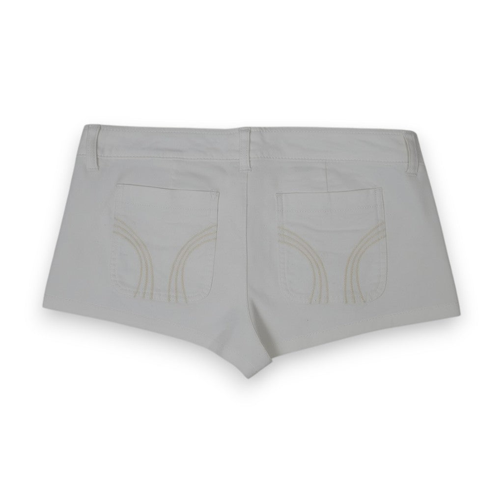Vista posteriore degli shorts in cotone bianco che mostra il taglio corto e le cuciture delle tasche sul retro.