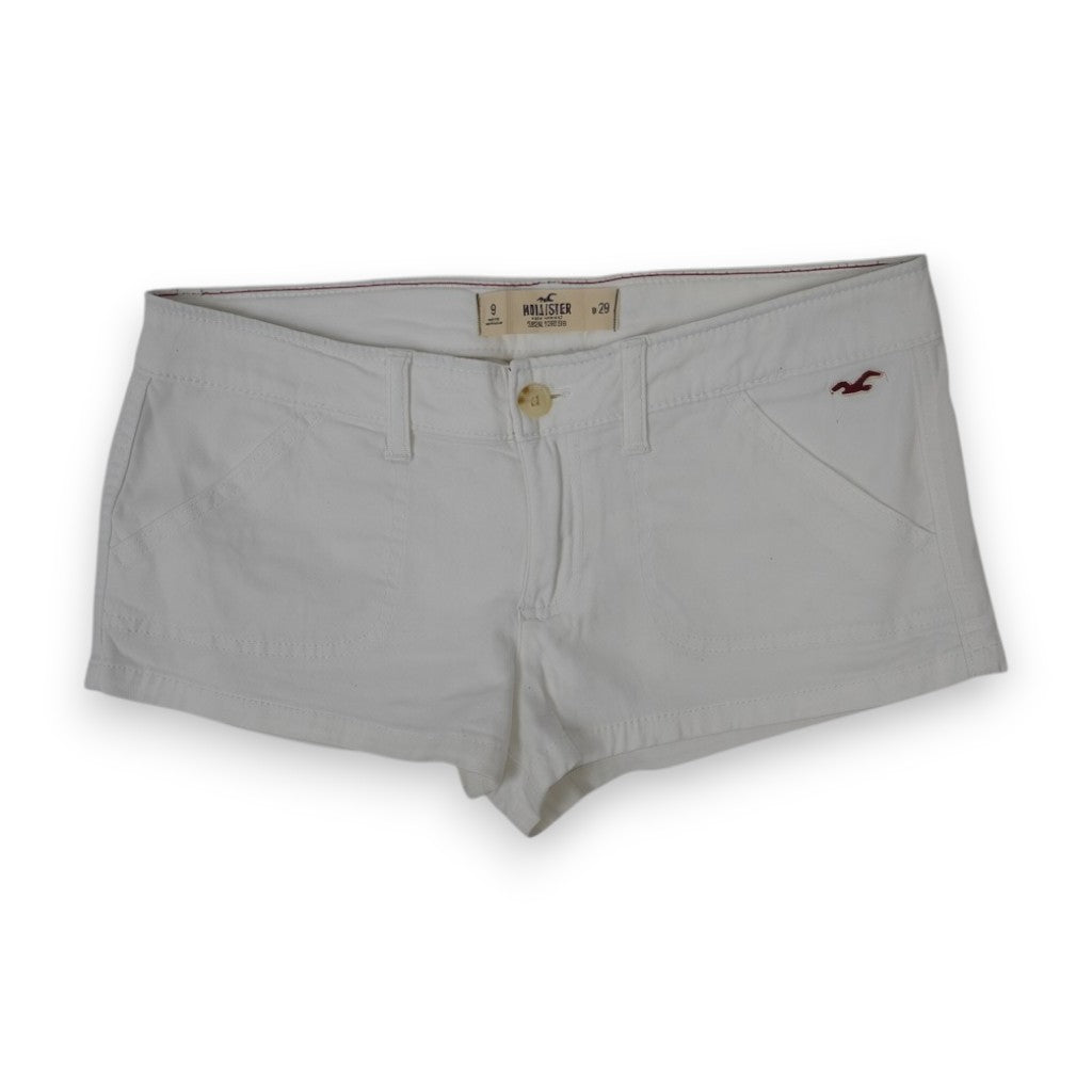 Vista frontale a figura intera degli shorts corti in cotone bianco Hollister con logo del gabbiano bordeaux sulla tasca sinistra