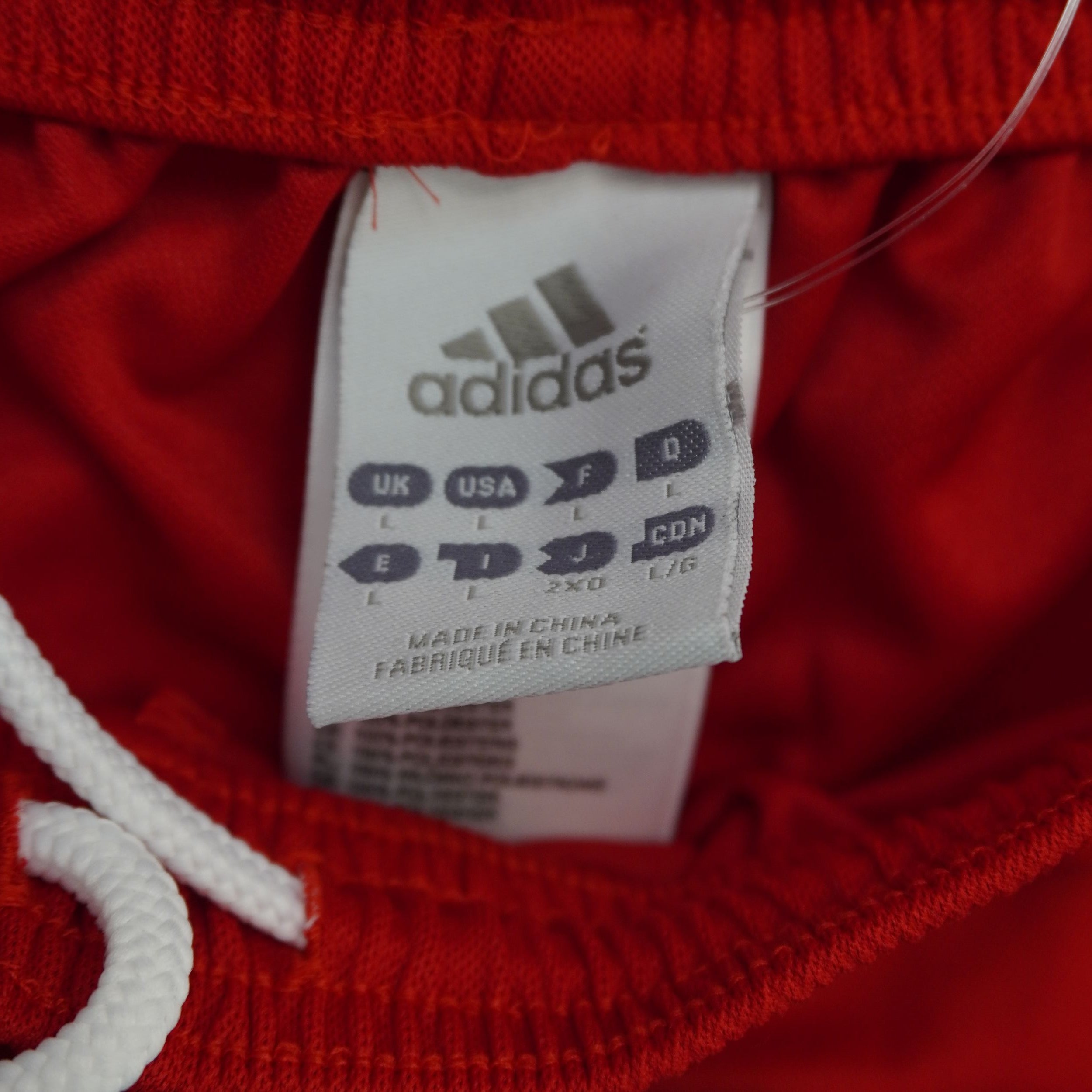 Etichetta interna originale adidas cucita sul girovita elasticizzato rosso vicino alla coulisse