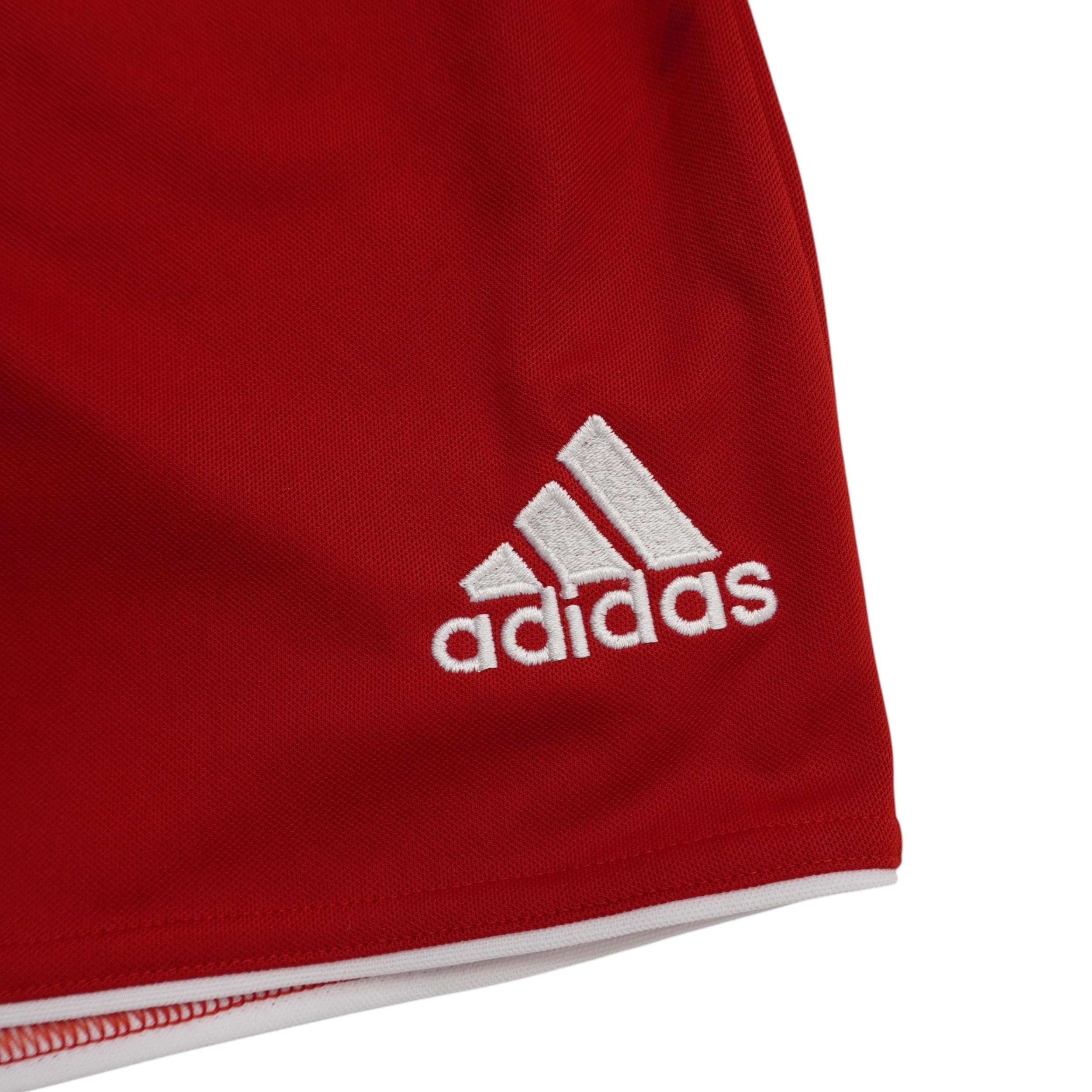 Inquadratura ravvicinata del logo Performance adidas originale ricamato in filo bianco sulla gamba sinistra