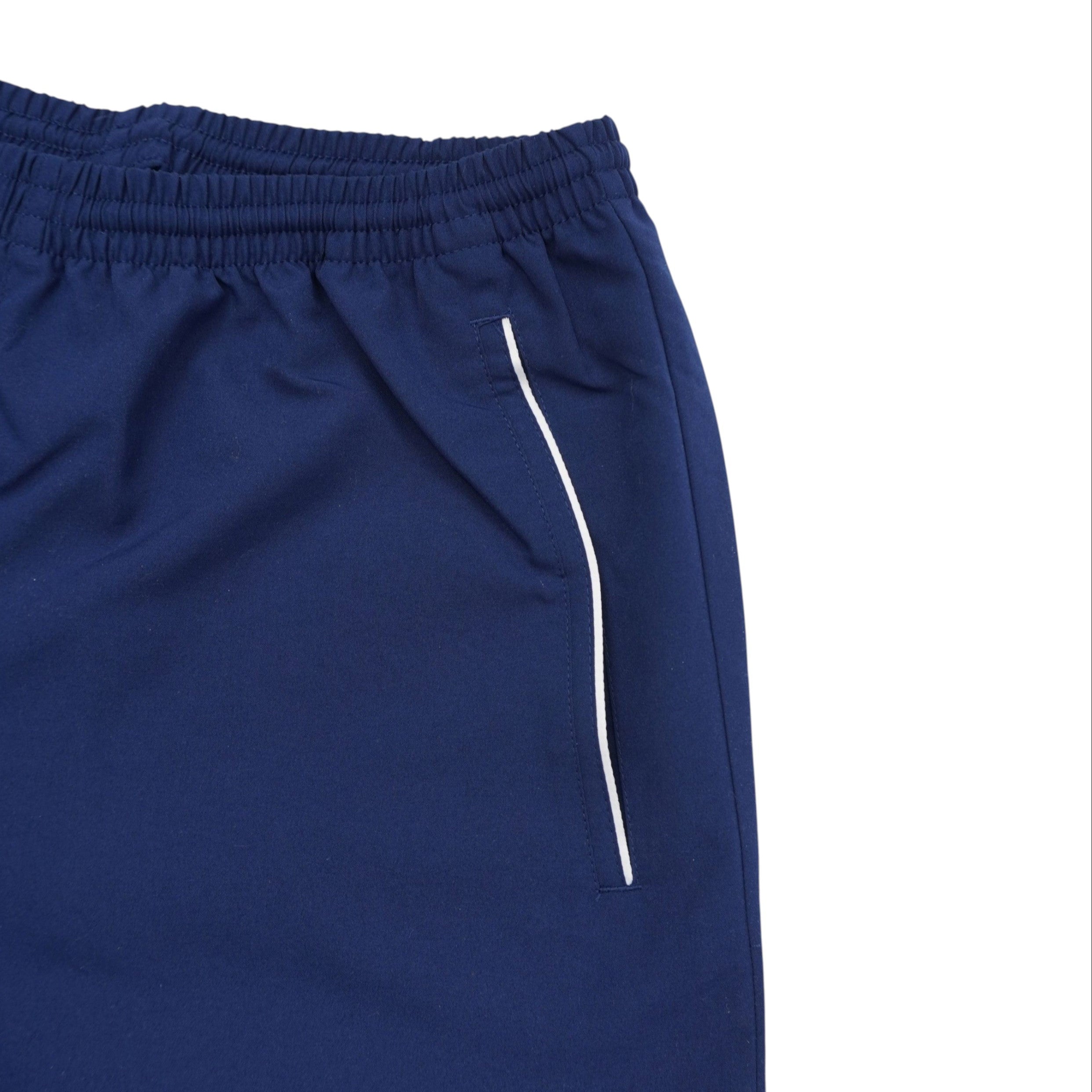 Particolare del fianco del pantaloncino blu navy che mostra la sottile riga bianca decorativa e le finiture delle cuciture