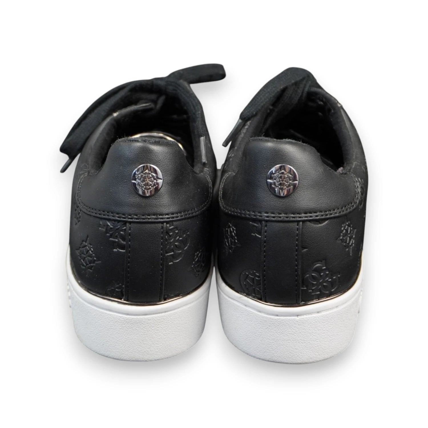 Profilo posteriore dei talloni delle sneakers Guess nere con bottoni metallici logati e finiture cromate