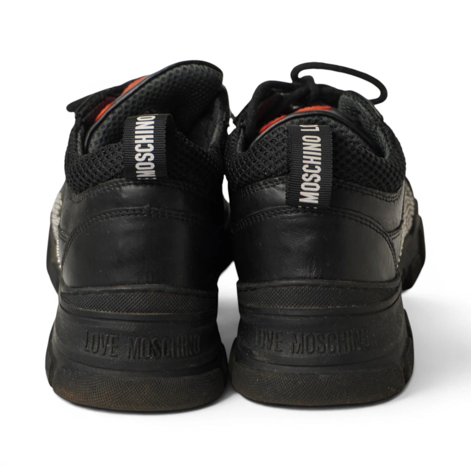 Vista posteriore dei talloni in pelle nera delle sneakers Love Moschino con scritte in rilievo sulla gomma.