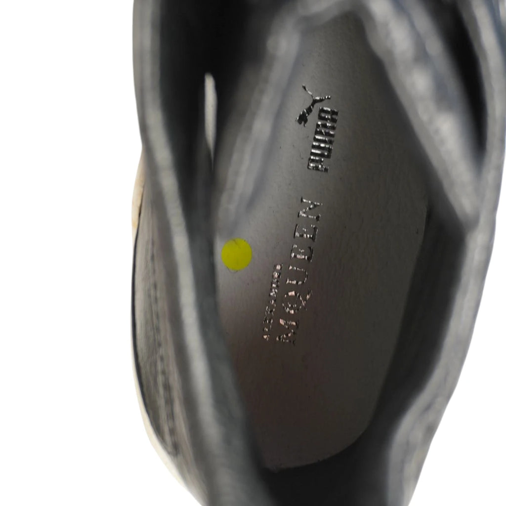 Vista interna della soletta in pelle grigia con loghi laminati argento Puma Alexander McQueen e bollino di controllo giallo