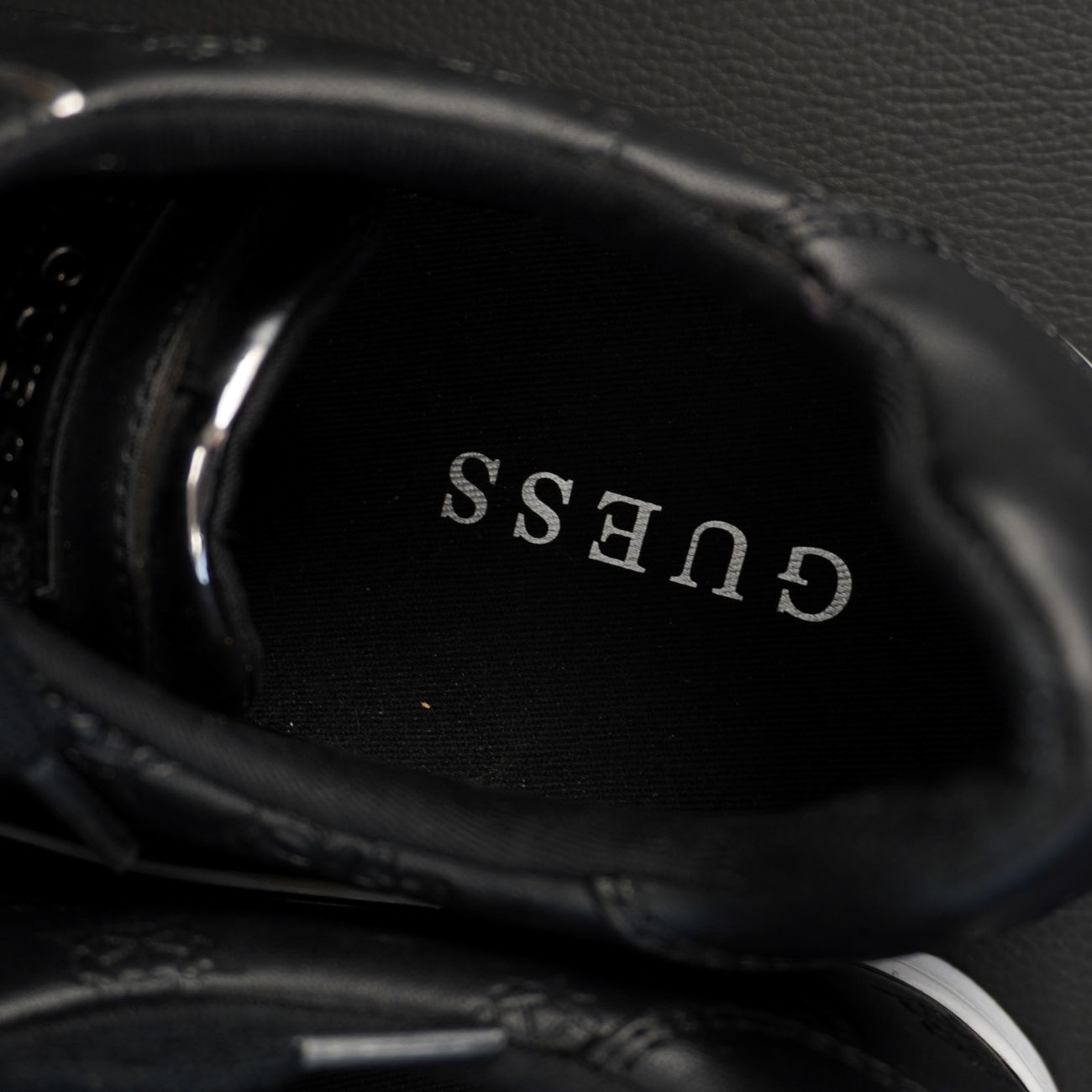 Vista dall'alto dell'interno della sneaker Guess con scritta del brand stampata in argento sulla soletta