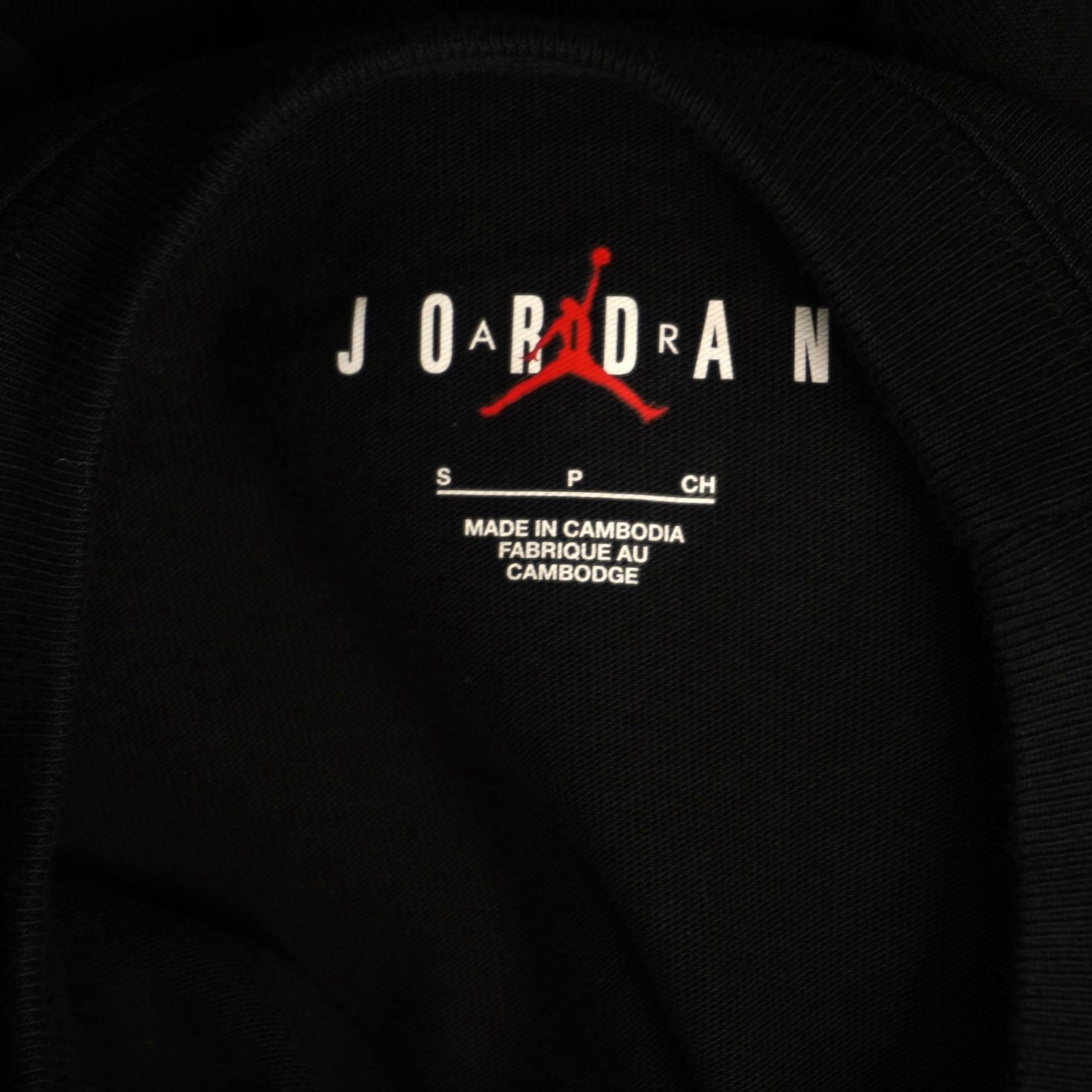 Primo piano della stampa interna al colletto con scritta Jordan rossa e taglia S.