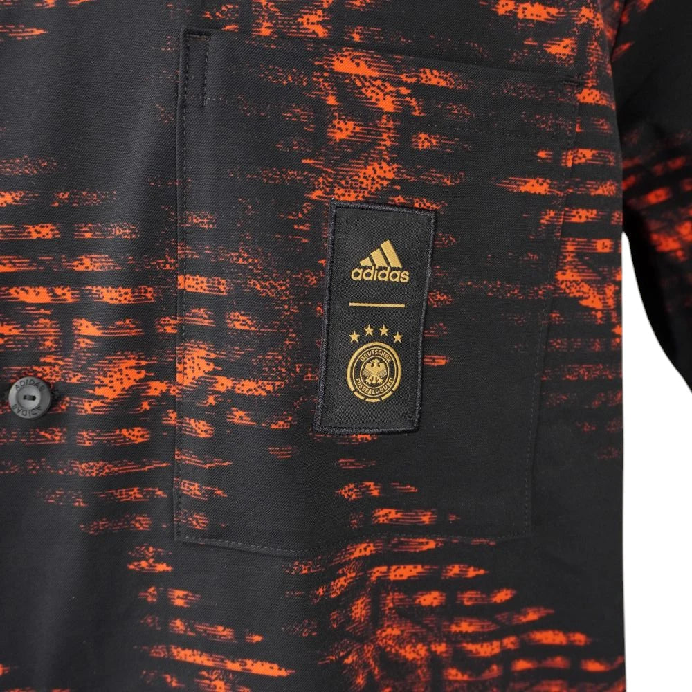 Dettaglio del taschino anteriore con la patch nera e oro del logo Adidas e dello stemma ufficiale della Federcalcio tedesca DFB.