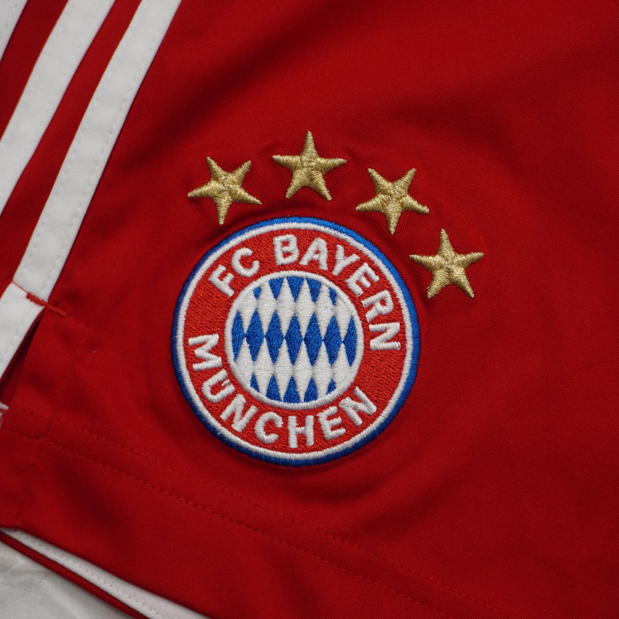  Primo piano dello stemma ufficiale del Bayern Monaco ricamato con le 4 stelle dorate sopra il logo del club.