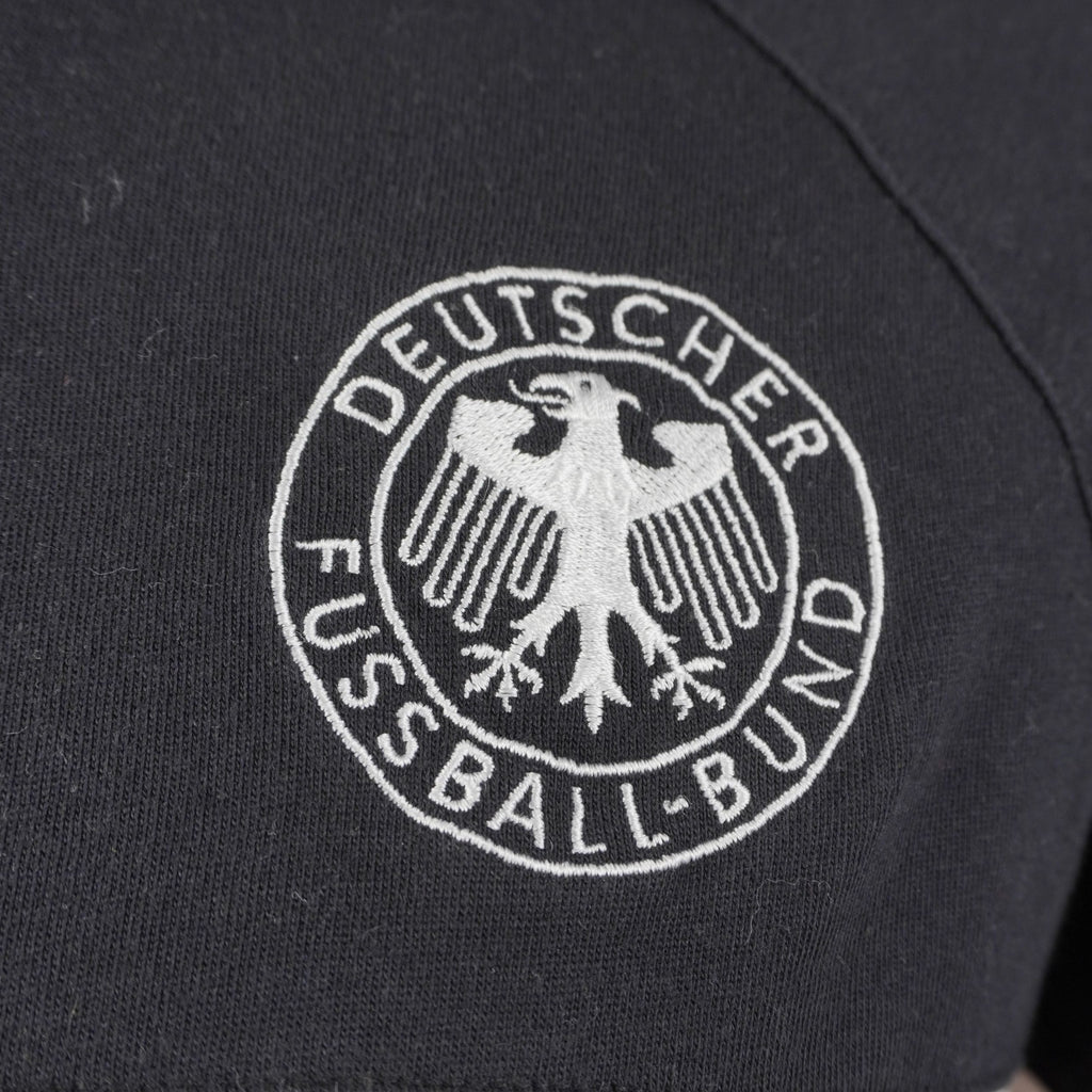 Dettaglio dello stemma ufficiale della federazione calcistica tedesca Deutscher Fussball-Bund ricamato in bianco e nero su tessuto.