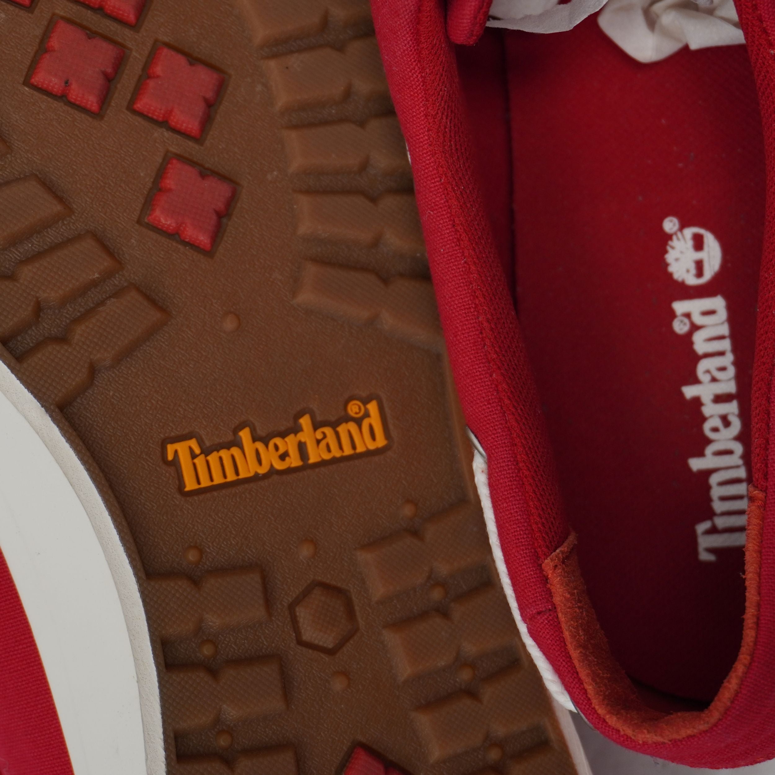 Particolare del battistrada in gomma marrone e della soletta interna rossa con marchio Timberland.