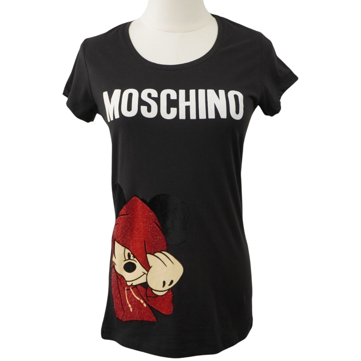 Vista frontale su manichino di una t-shirt nera da donna Moschino con logo bianco sul petto e stampa di Topolino con cappuccio rosso.