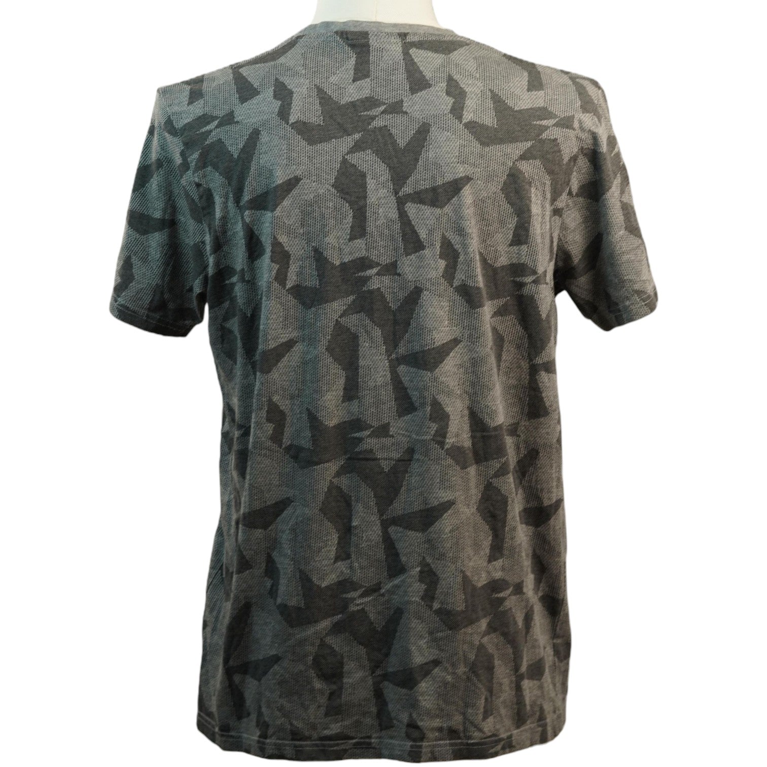Vista posteriore della t-shirt grigia con motivo camouflage geometrico continuo stampato su tutta la schiena.
