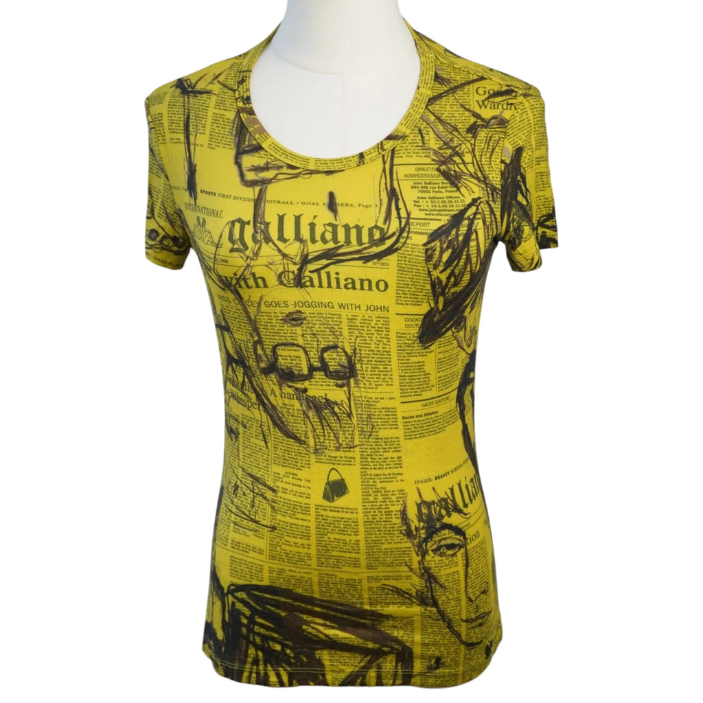 Vista frontale su manichino della t-shirt vintage John Galliano in cotone giallo ocra con l'iconica stampa a giornale nera.