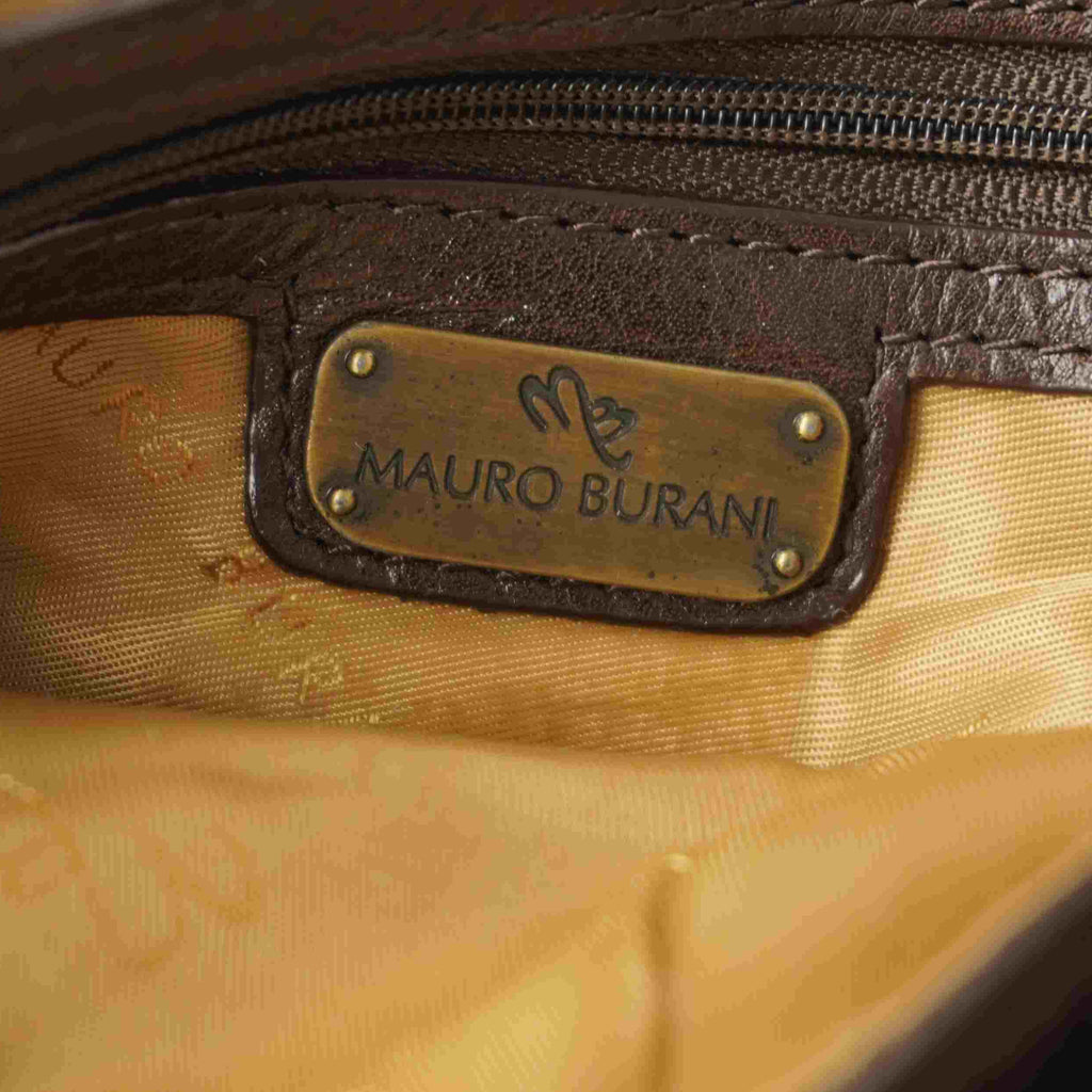  Dettaglio della targhetta interna dorata con il brand Mauro Burani applicata sulla fodera satinata.