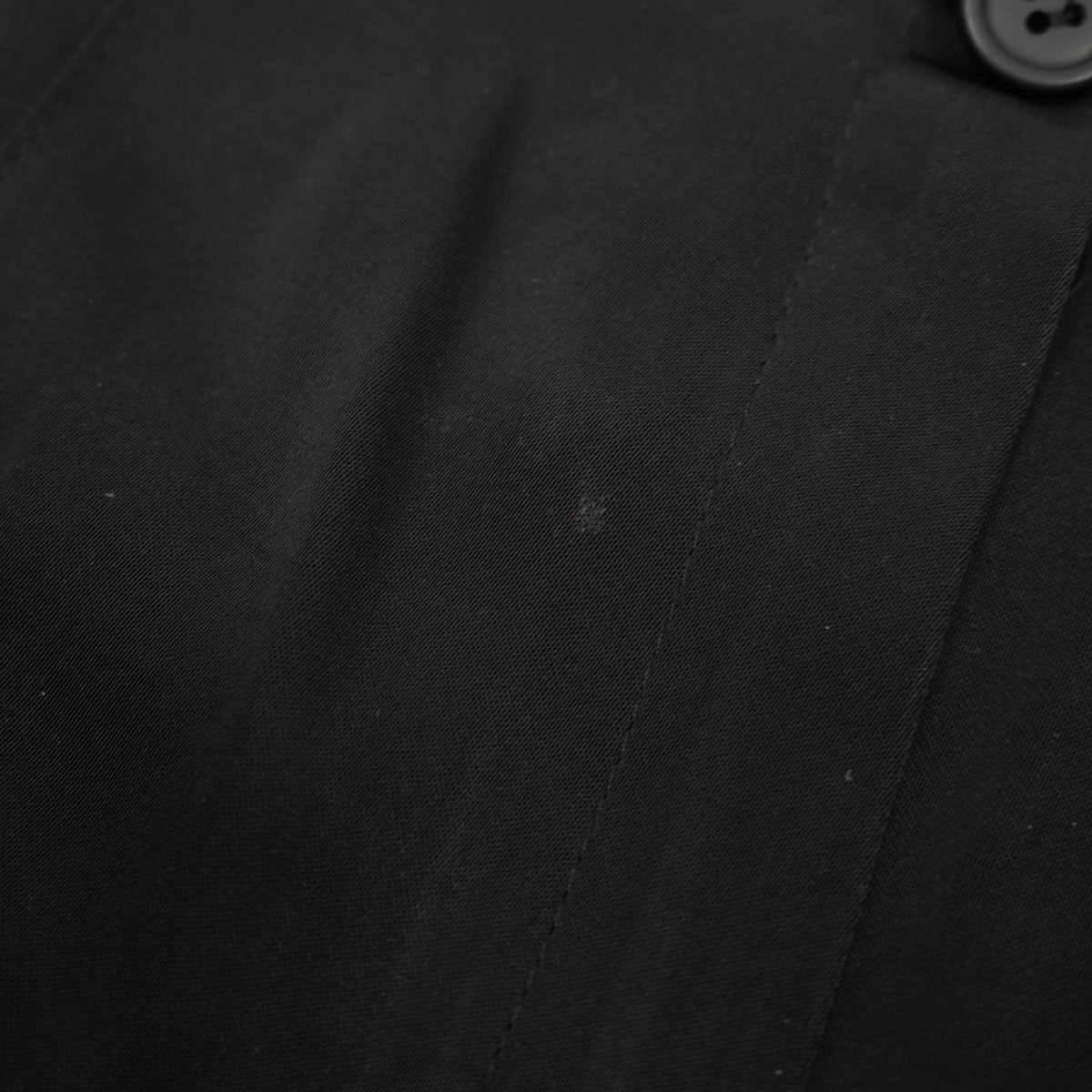 Zoom macro sulla trama del tessuto nero satinato che mostra un leggero segno superficiale dell'usura.