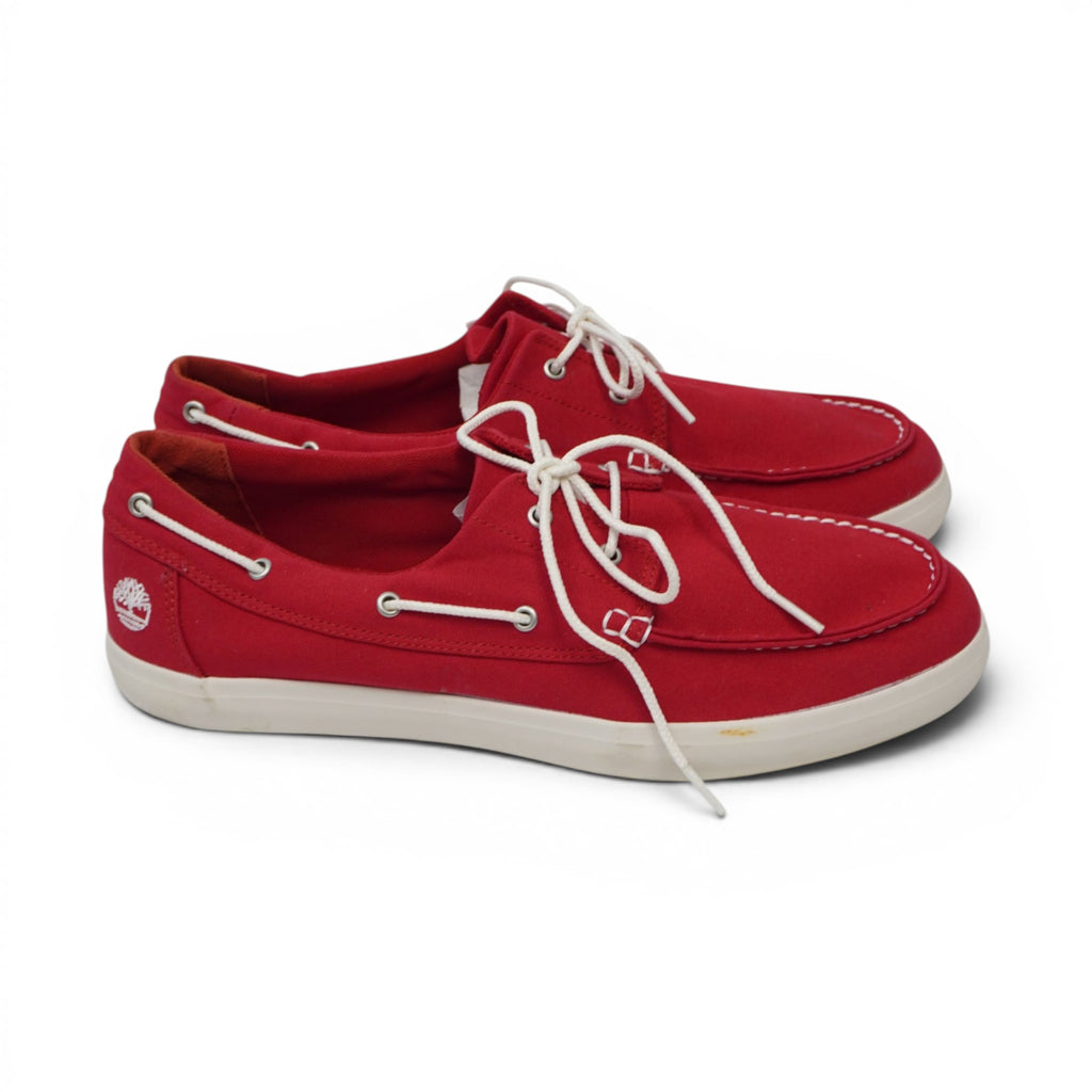 Vista laterale di profilo delle scarpe nautiche Timberland rosse in canvas con suola bianca.