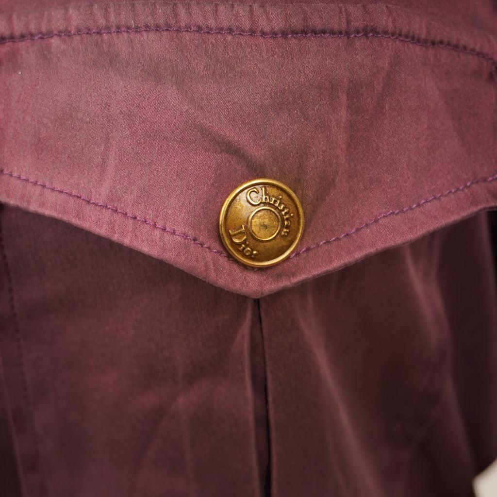Dettaglio ravvicinato della patta del taschino sinistro del top Dior bordeaux che mostra la piccola macchia superficiale sul tessuto in seta.