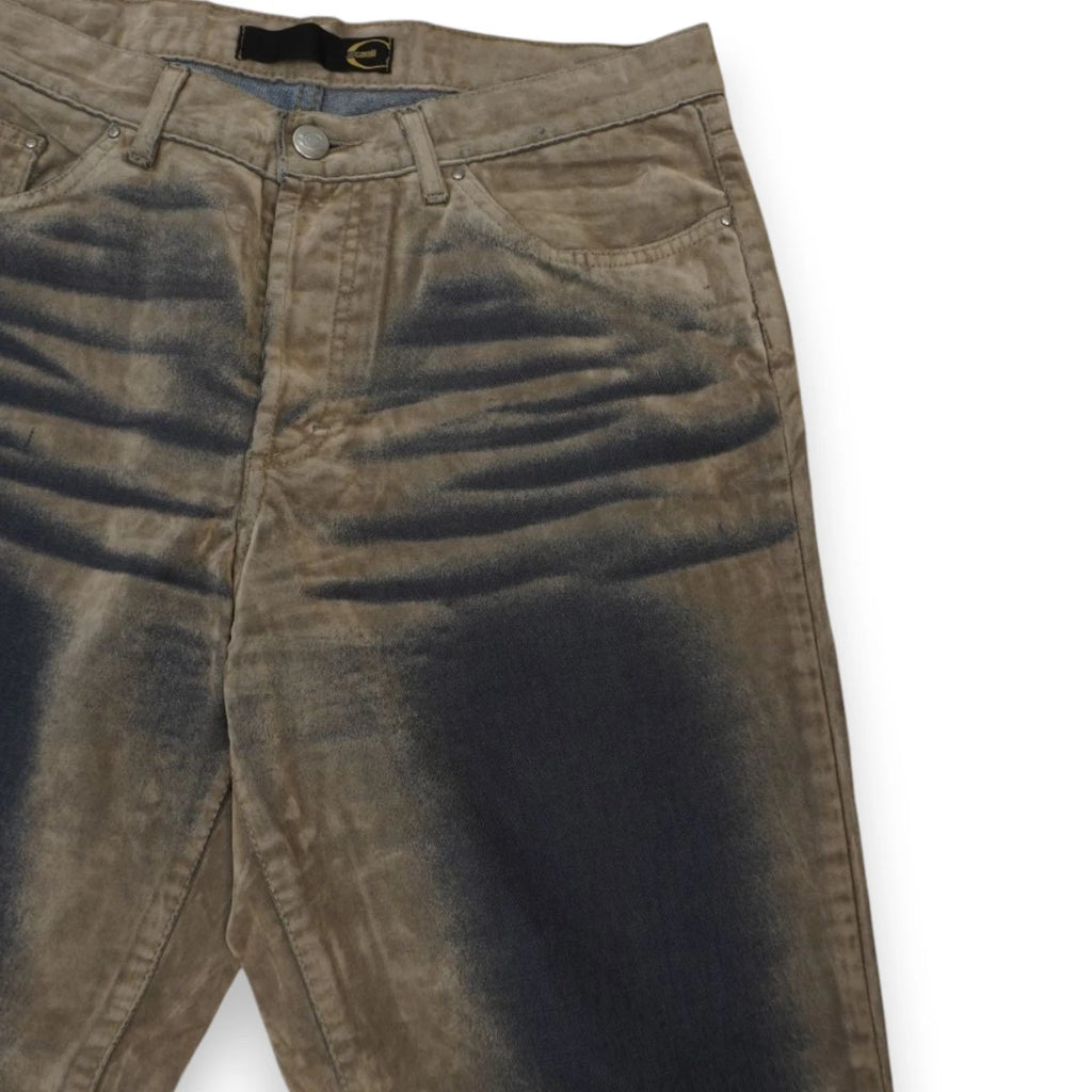 Dettaglio ravvicinato della gamba sinistra dei pantaloni Cavalli con transizione sfumata del pigmento blu scuro sul tessuto scamosciato.