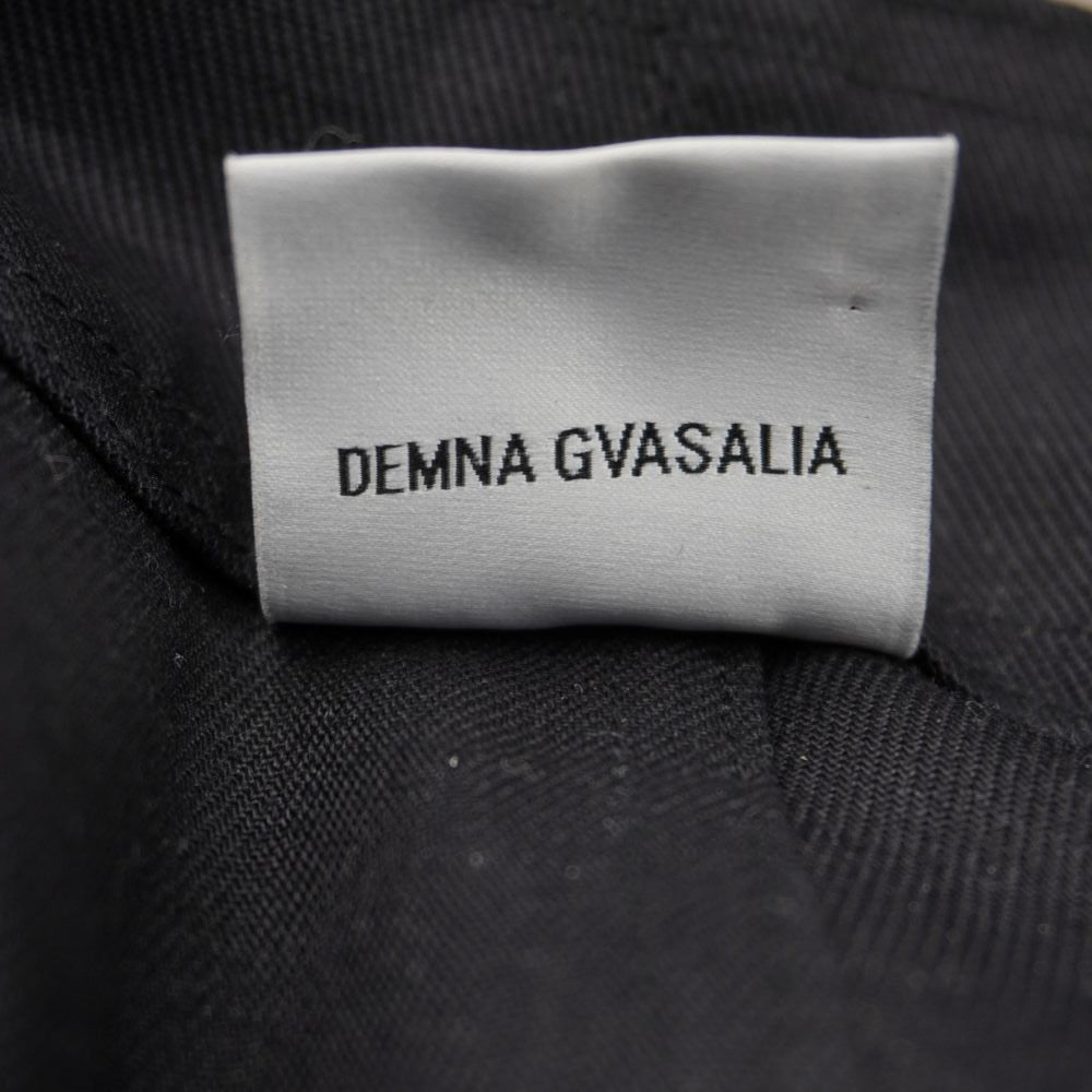 Dettaglio dell'etichetta di autenticità ricamata con il nome dello stilista Demna Gvasalia su sfondo nero all'interno del capo Vetements.