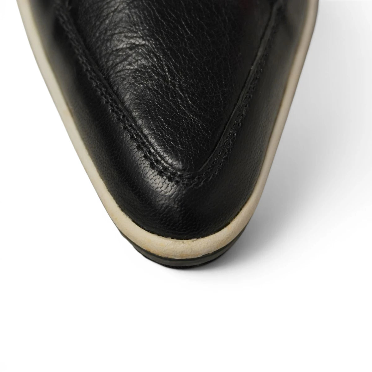 Primo piano frontale della punta a falce in pelle nera e suola ingiallita sneaker Puma x Alexander McQueen